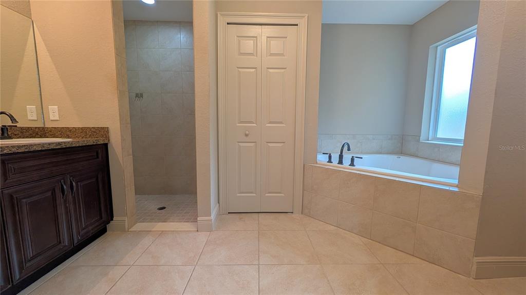 8802 Southwest 135th Place Ocala, FL 34473 - Photo 33 of 39 a bathroom with a tub sink vanity and a mirror