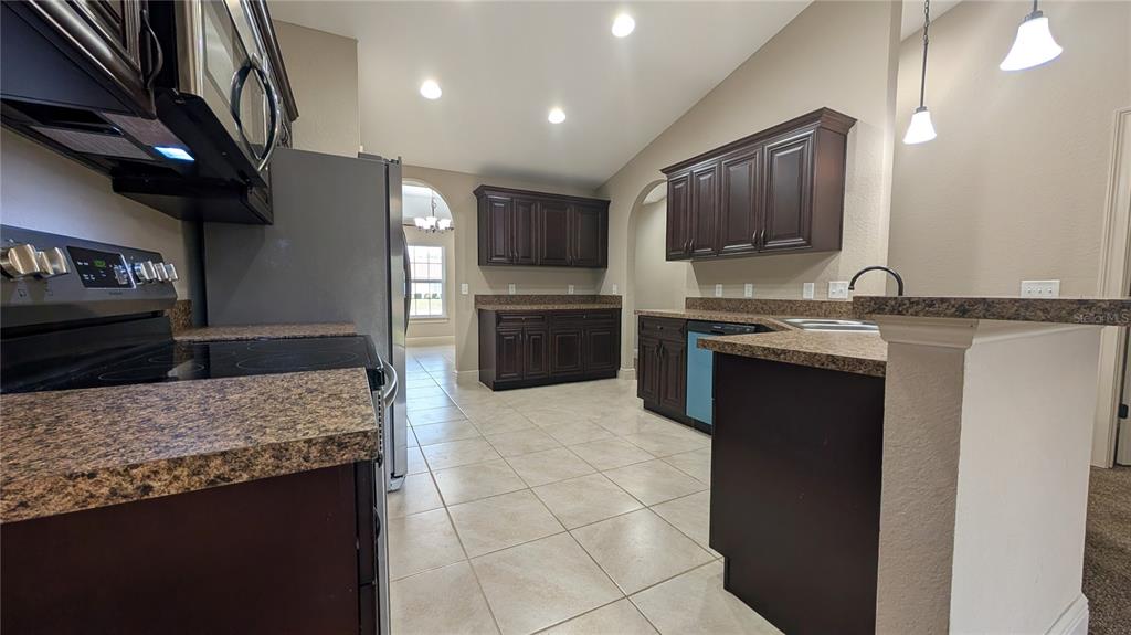 8802 Southwest 135th Place Ocala, FL 34473 - Photo 7 of 39 a kitchen with stainless steel appliances granite countertop a sink and a stove