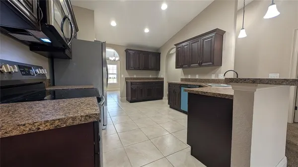 a kitchen with stainless steel appliances granite countertop a sink and a stove