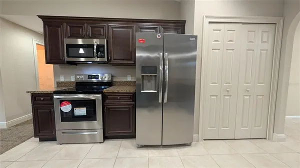 a kitchen with stainless steel appliances granite countertop a refrigerator and a stove