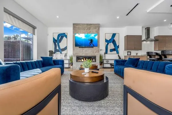 a living room with furniture a fireplace and a chandelier