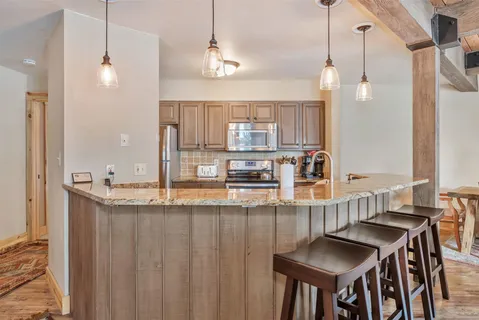 a kitchen with kitchen island granite countertop a table and chairs in it
