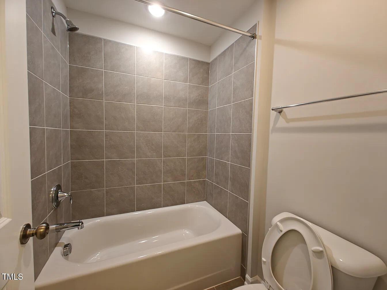 2409 Englemann Drive Apex, NC 27502 - Photo 20 of 25 a bathroom with a bathtub a toilet and a shower