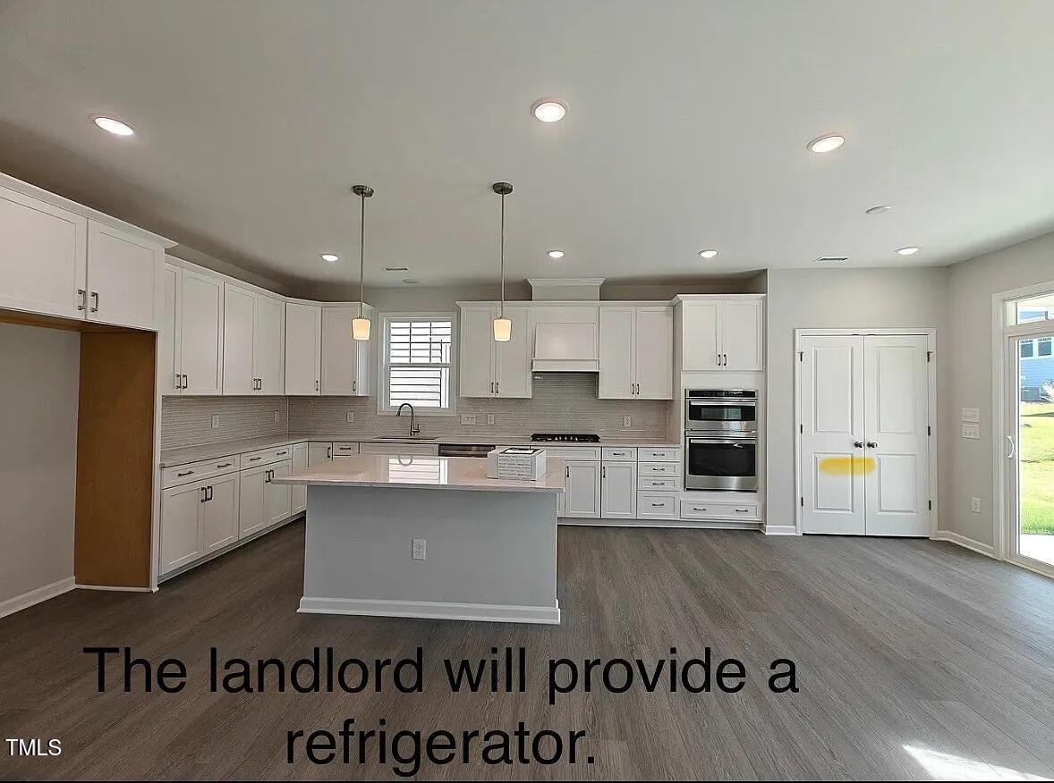 2409 Englemann Drive Apex, NC 27502 - Photo 4 of 25 a kitchen with stainless steel appliances granite countertop a refrigerator a stove and a sink