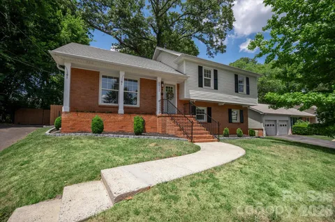 a front view of a house with a yard and trees