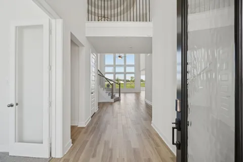 a view of a hallway with wooden floor and a living room