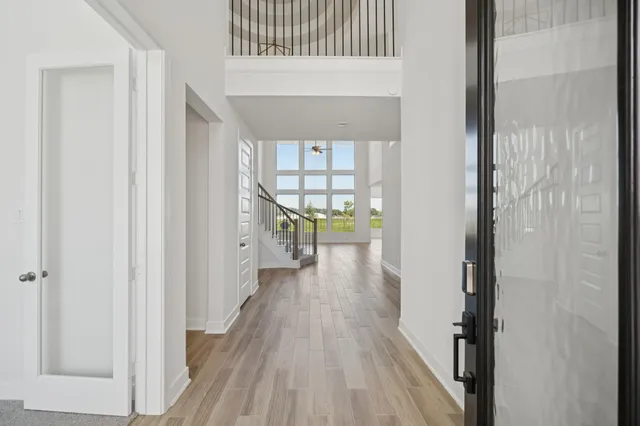a view of a hallway with wooden floor and a living room