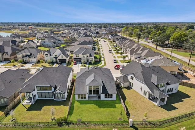 an aerial view of residential houses with outdoor space and swimming pool
