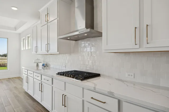 a kitchen with stainless steel appliances granite countertop white cabinets and a stove