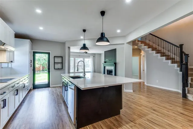 a kitchen with counter top space sink and wooden floor
