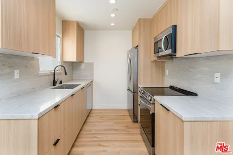a kitchen with stainless steel appliances granite countertop a refrigerator stove and microwave