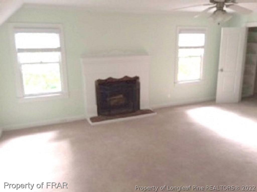 3124 Brechin Road Fayetteville, NC 28303 - Photo 15 of 18 an empty room with windows and a chandelier fan