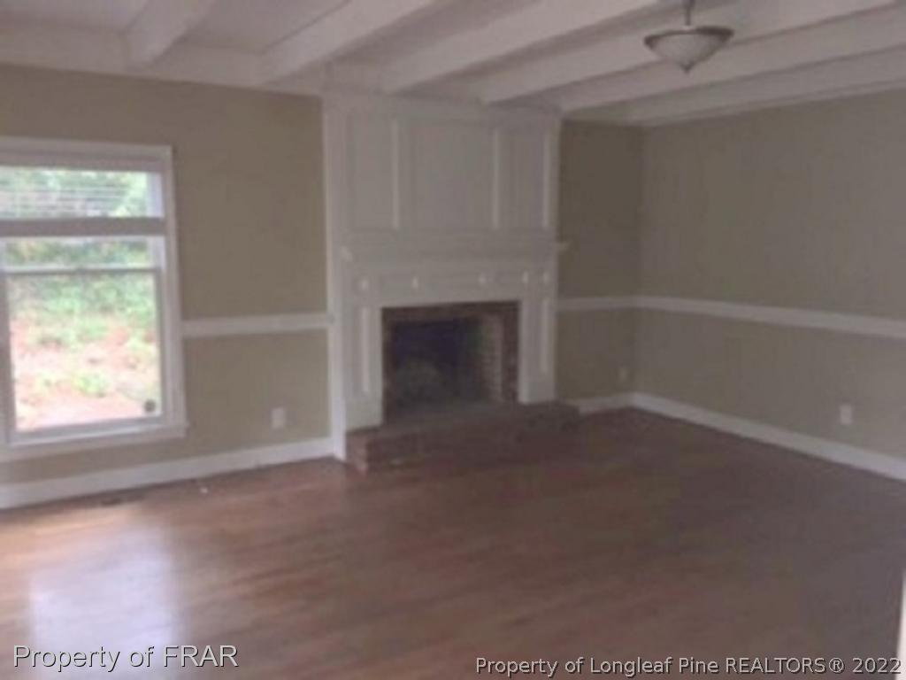 3124 Brechin Road Fayetteville, NC 28303 - Photo 16 of 18 an empty room with a fireplace and windows