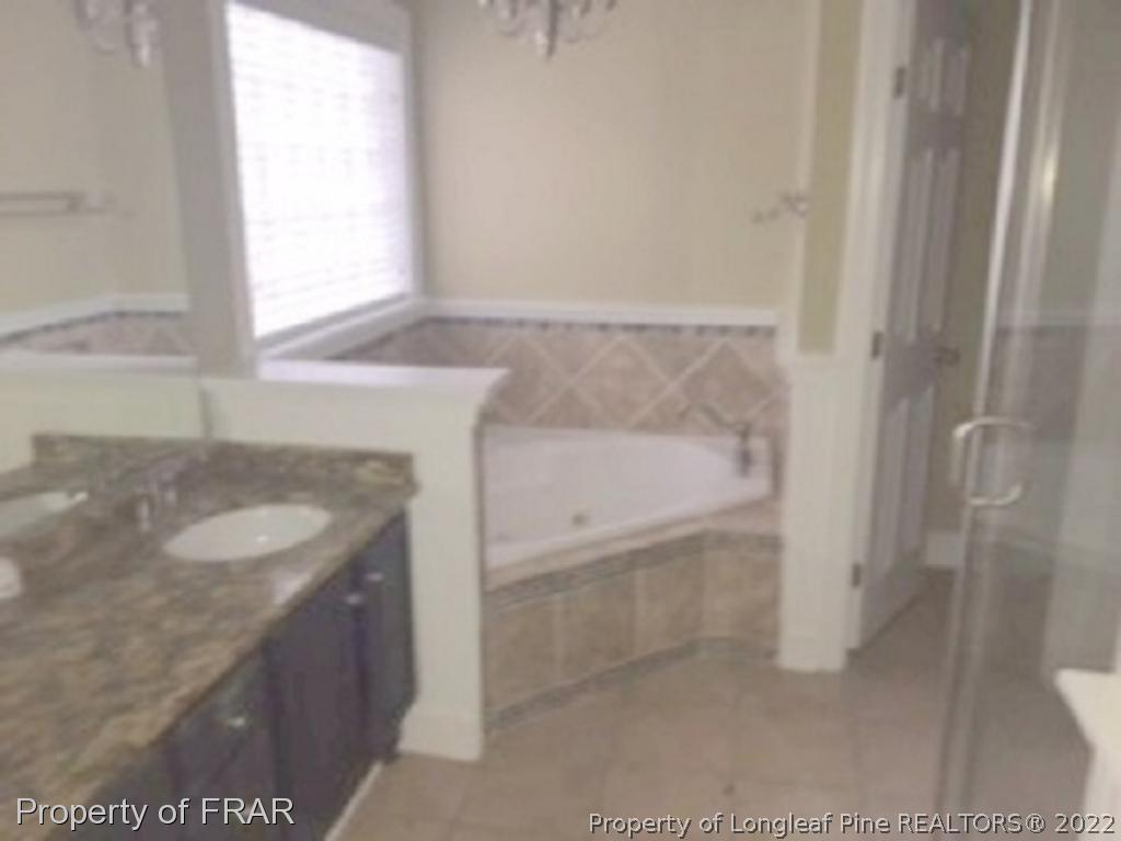 3124 Brechin Road Fayetteville, NC 28303 - Photo 7 of 18 a bathroom with a granite countertop sink and a bathtub