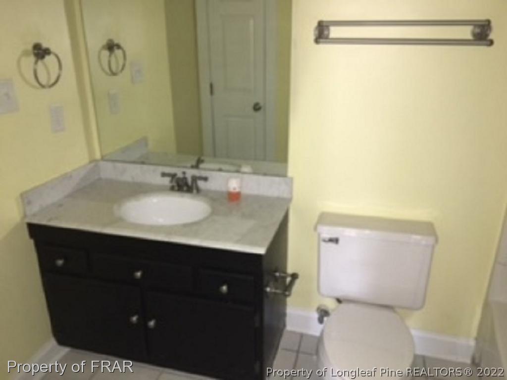 3124 Brechin Road Fayetteville, NC 28303 - Photo 10 of 18 a bathroom with a sink vanity mirror and toilet