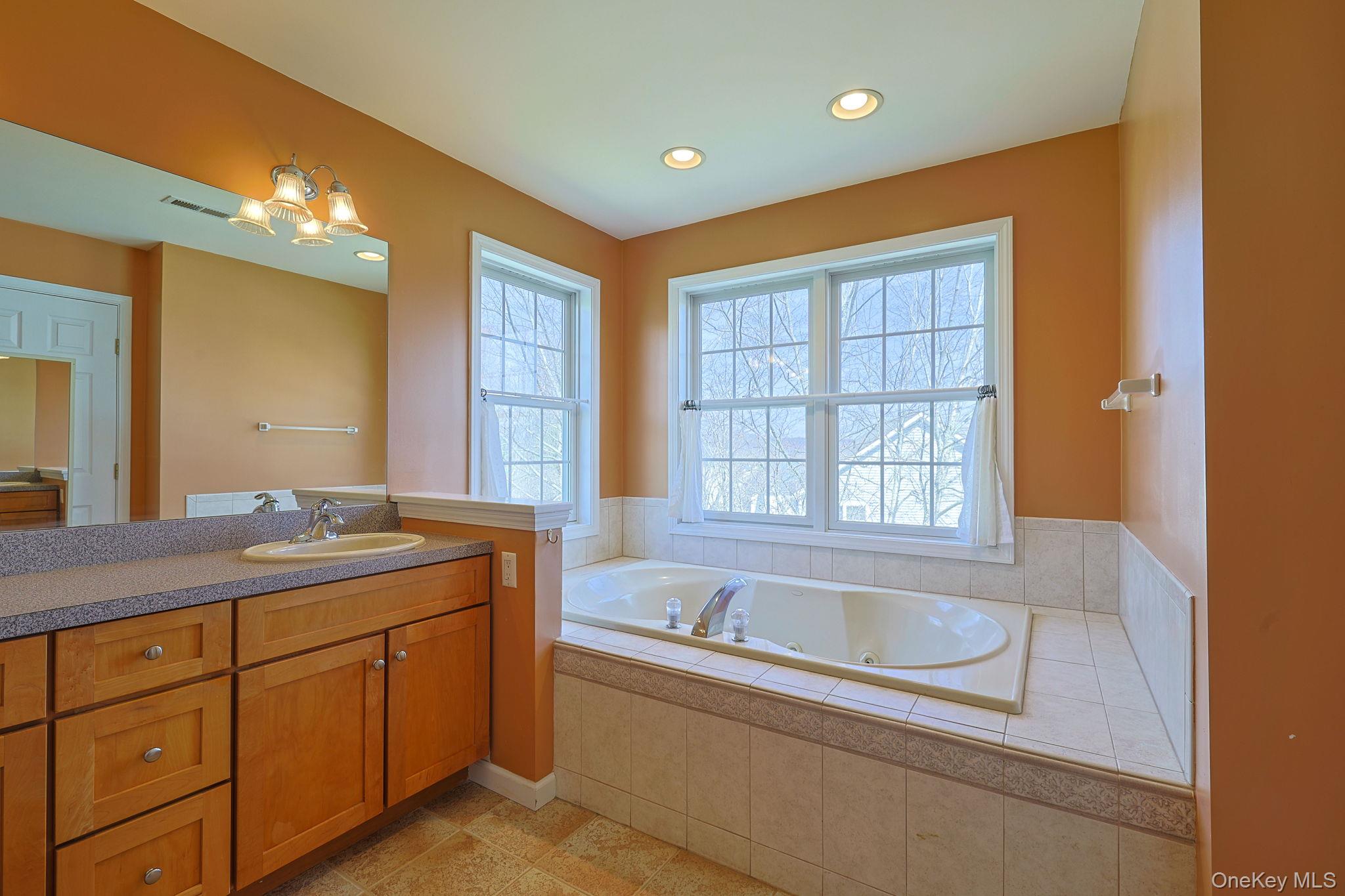 99 Country Club Road Hopewell Junction, NY 12533 - Photo 19 of 44 a bathroom with a granite countertop sink mirror bathtub and shower