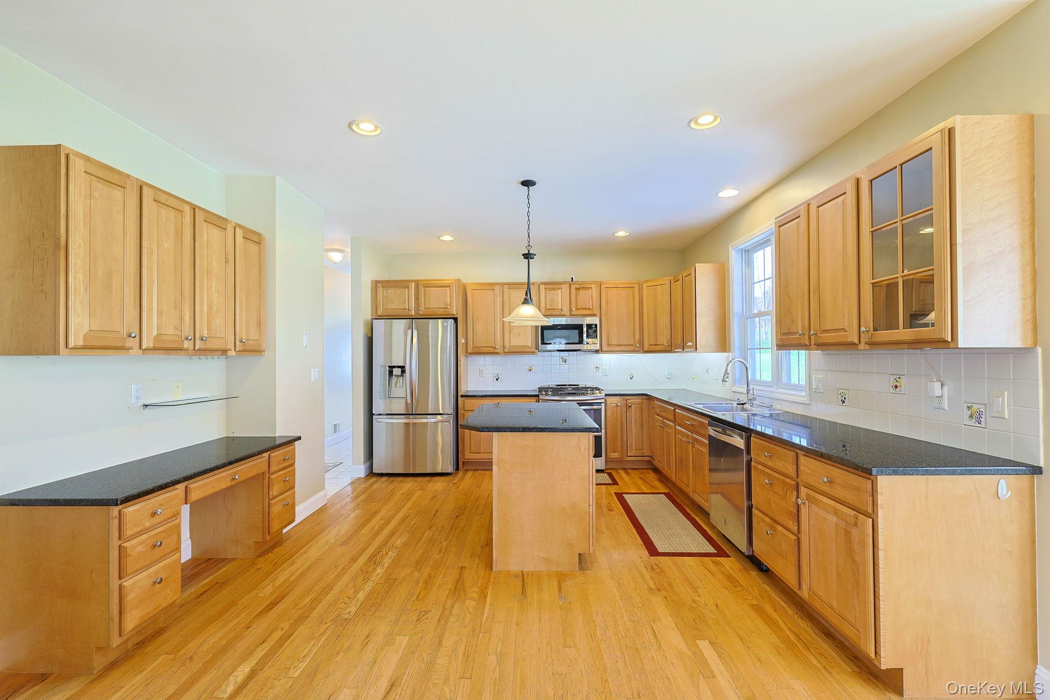 99 Country Club Road Hopewell Junction, NY 12533 - Photo 7 of 44 a large kitchen with stainless steel appliances granite countertop a large kitchen island a stove a sink dishwasher and a refrigerator with wooden floor
