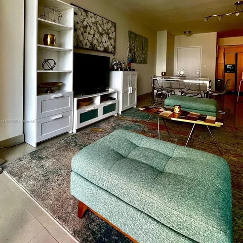 a living room with furniture flat screen tv and outdoor view