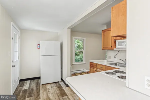 a kitchen with a sink a refrigerator and wooden floor