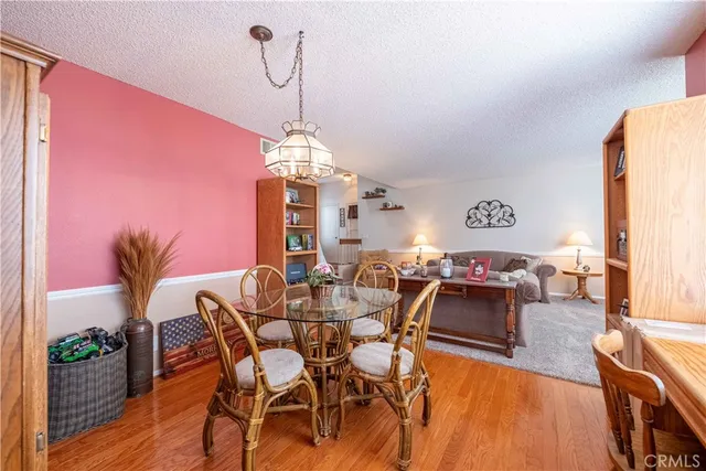 a kitchen with stainless steel appliances granite countertop a stove top oven a sink a dining table and chairs