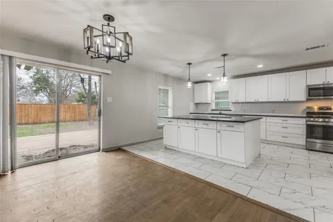 a large kitchen with stainless steel appliances kitchen island granite countertop a sink and cabinets
