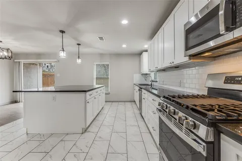 a bedroom with a large bed a chandelier and a window