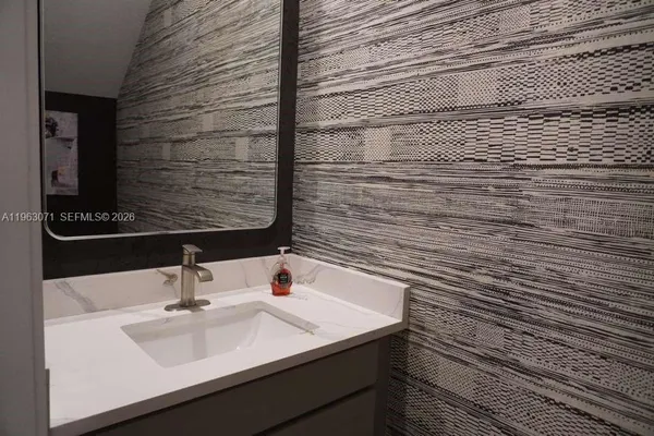 a bathroom with a granite countertop toilet a sink a mirror a bathtub and shower