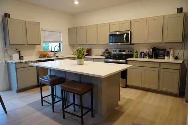a kitchen with a sink cabinets and wooden floor
