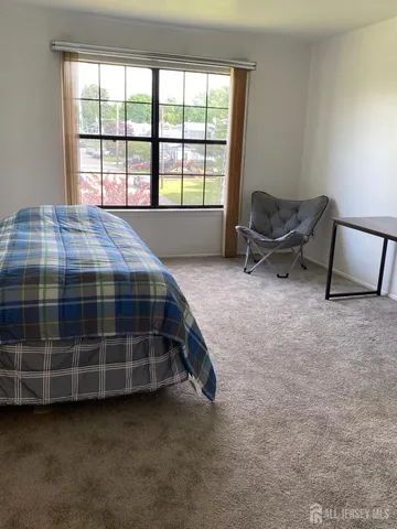 a spacious bedroom with a bed and a window