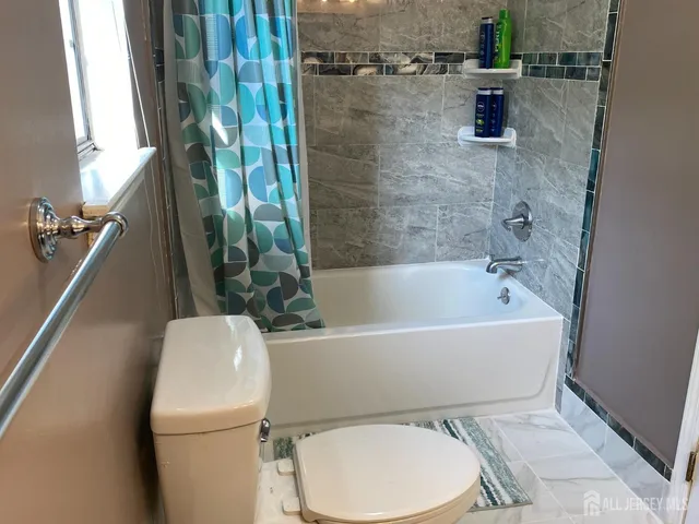 a white toilet sitting next to a bath tub