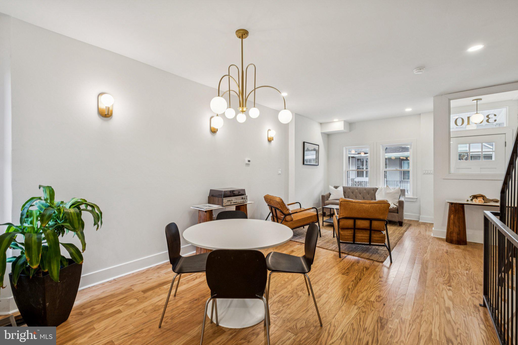3010 Redner Street Philadelphia, PA 19121 - Photo 4 of 27 a dining room with wooden floor a chandelier a wooden table and chairs