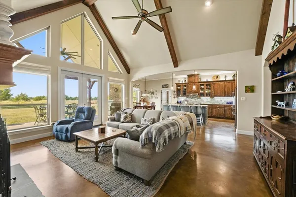 a living room with furniture floor to ceiling window and a flat screen tv