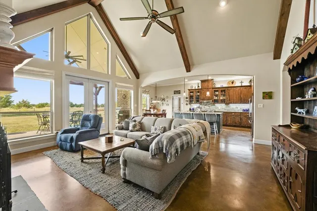 a living room with furniture floor to ceiling window and a flat screen tv