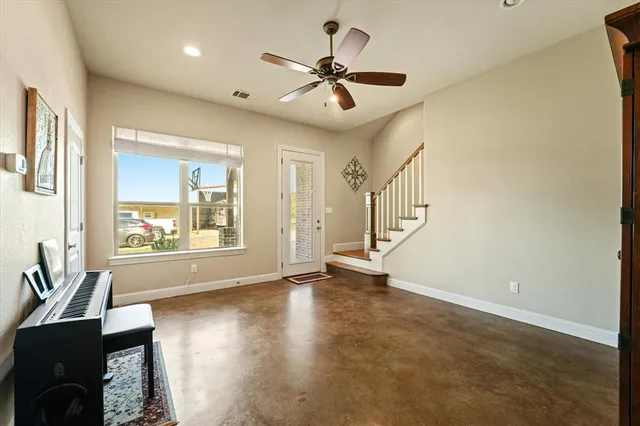 a view of an empty room with a window and a fireplace