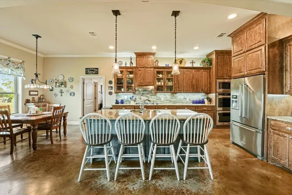 a dining room with furniture a kitchen and chandelier