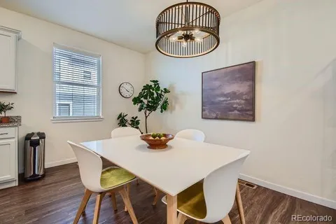 a dining room with furniture a potted plant and a chandelier