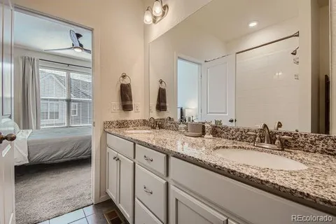 a en suite bathroom with a granite countertop sink and a mirror