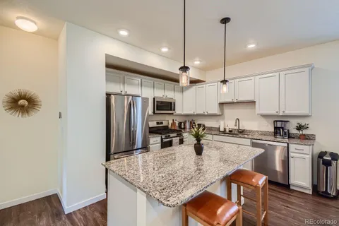a kitchen with stainless steel appliances granite countertop a sink refrigerator and microwave