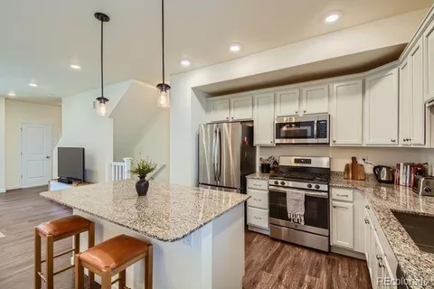 a kitchen with stainless steel appliances granite countertop a sink refrigerator and microwave