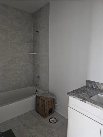 a bathroom with a granite countertop sink a toilet and bathtub