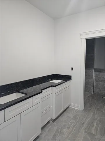 a kitchen with granite countertop white cabinets and a sink