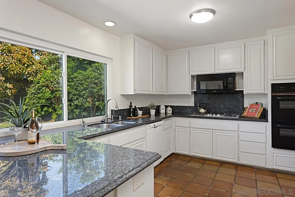 4520 Trieste Drive Carlsbad, CA 92010 - Photo 12 of 27 a kitchen with stainless steel appliances granite countertop a sink and a stove