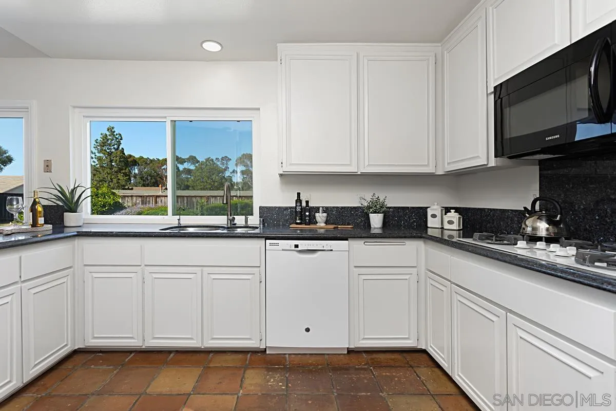 4520 Trieste Drive Carlsbad, CA 92010 - Photo 13 of 27 a kitchen with white cabinets and sink