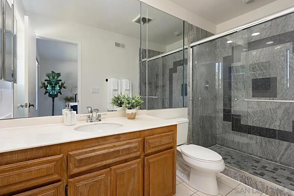 4520 Trieste Drive Carlsbad, CA 92010 - Photo 22 of 27 a bathroom with a sink vanity granite toilet and shower