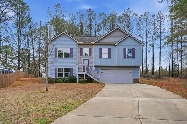 a front view of a house with a yard and trees