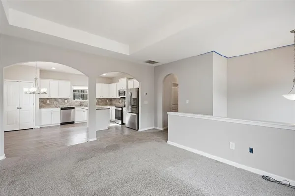 a view of kitchen with white cabinets and stainless steel appliances