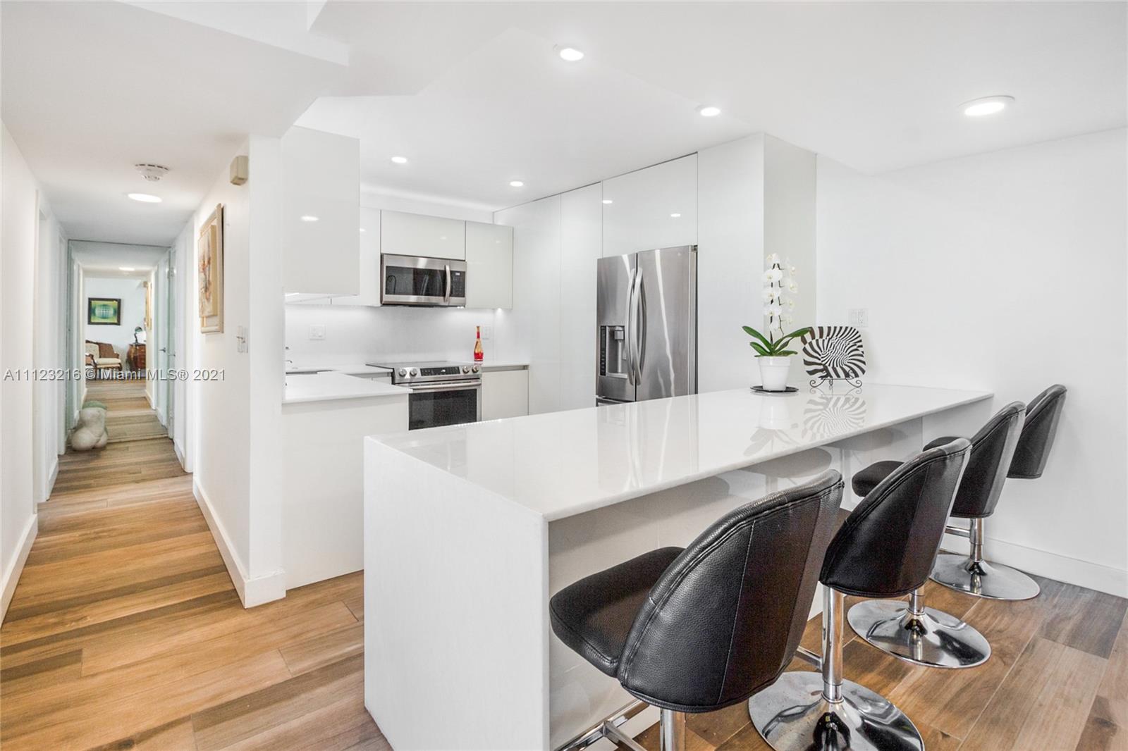11111 Biscayne Boulevard, Unit 7C Miami, FL 33181 - Photo 2 of 18 a kitchen with stainless steel appliances kitchen island a refrigerator and wooden floor