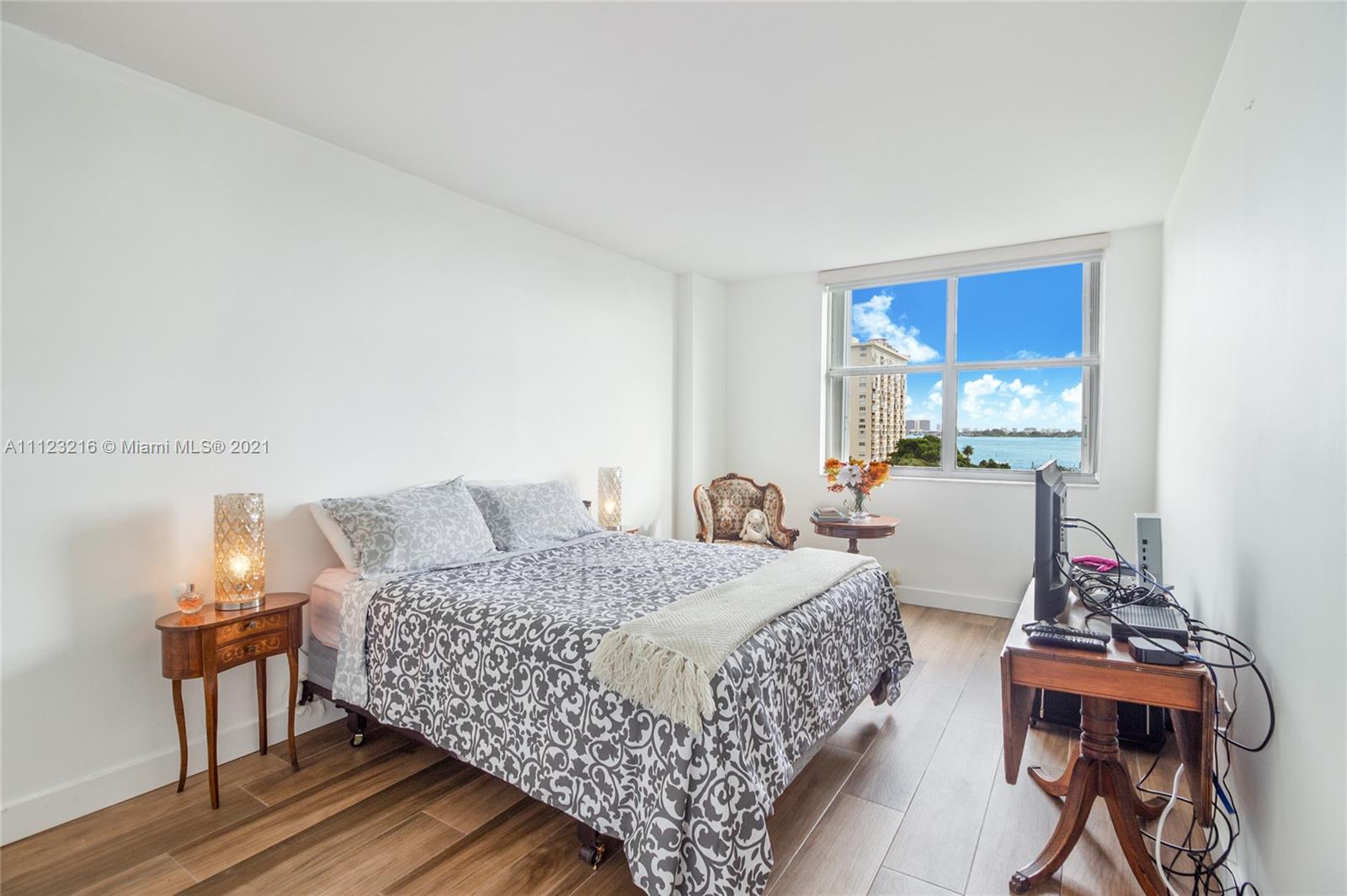 11111 Biscayne Boulevard, Unit 7C Miami, FL 33181 - Photo 8 of 18 a bedroom with a bed and wooden floor