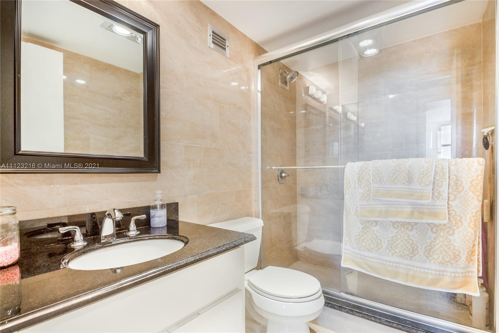 11111 Biscayne Boulevard, Unit 7C Miami, FL 33181 - Photo 9 of 18 a bathroom with a granite countertop sink toilet and shower