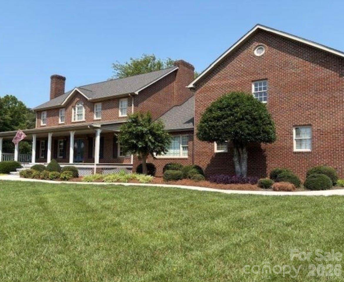 a front view of a house with a yard and potted plants